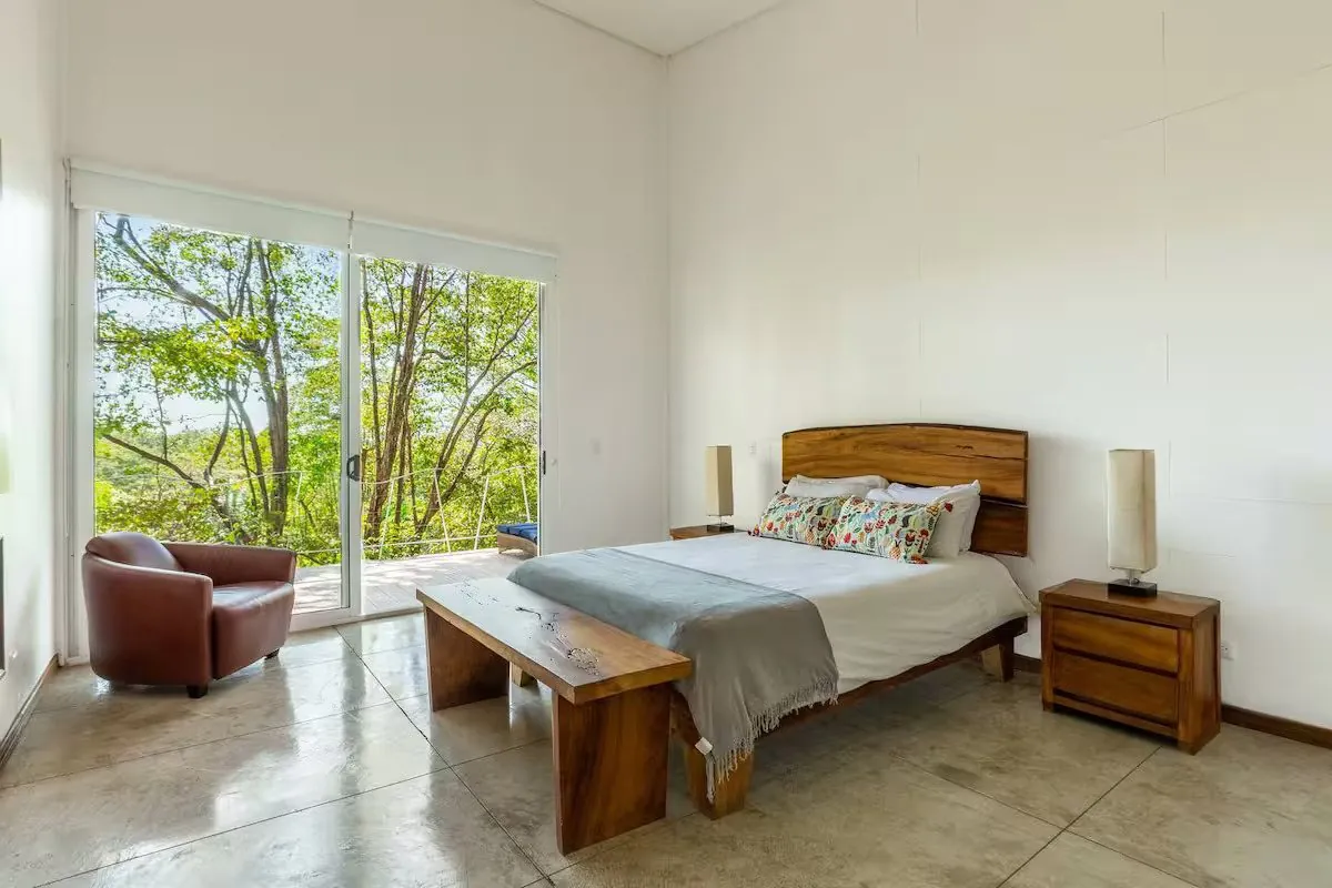 Bedroom two with a wall of glass onto the trees